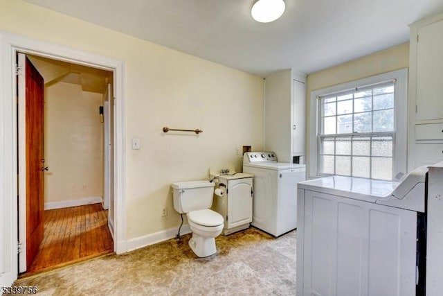 bathroom with washer / clothes dryer, toilet, and baseboards