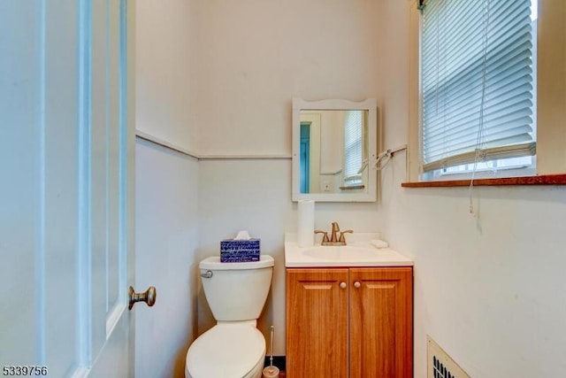 half bath featuring toilet, visible vents, and vanity