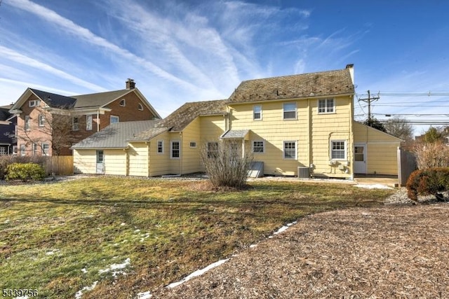 back of property featuring a yard, central AC unit, and fence