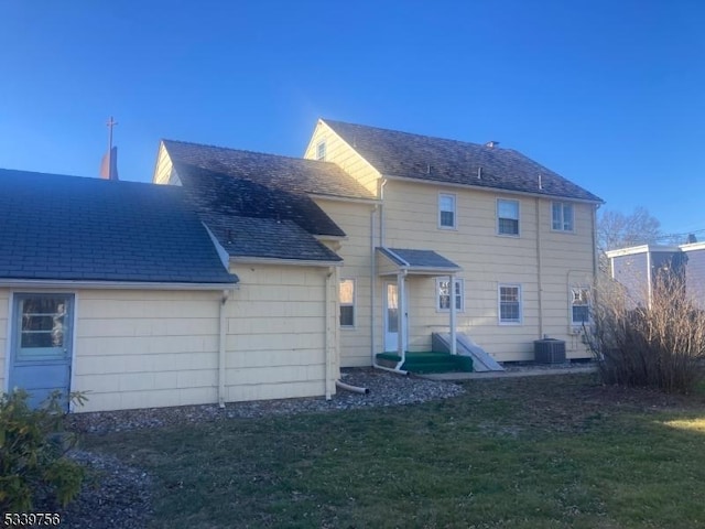 back of property with a lawn and central air condition unit