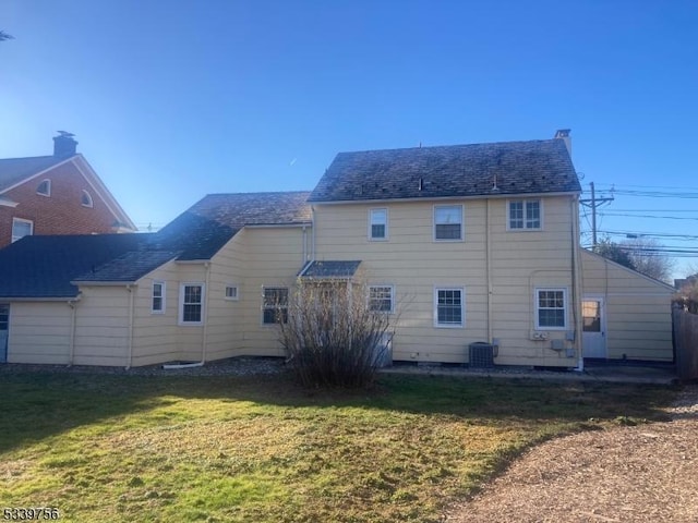 back of property with a lawn and central air condition unit