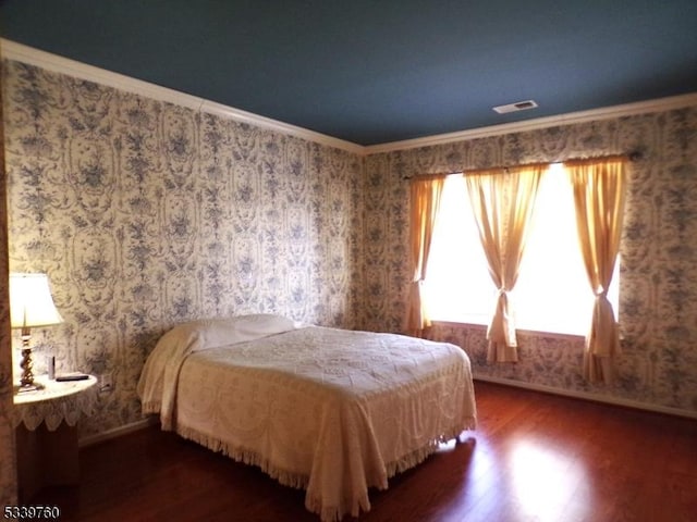 bedroom with wallpapered walls, visible vents, ornamental molding, and dark wood-type flooring