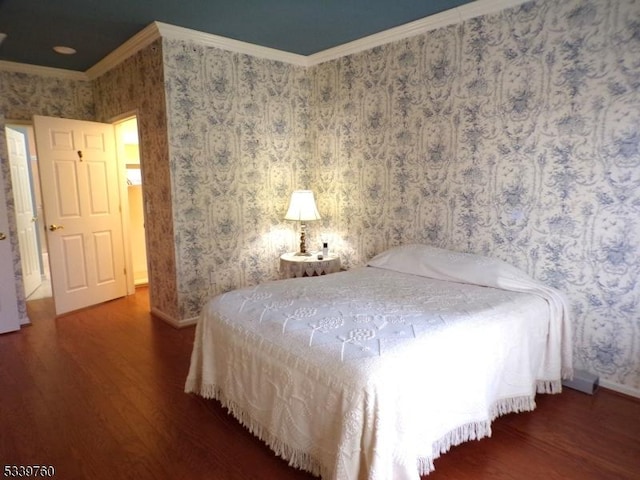 bedroom featuring crown molding, dark wood finished floors, baseboards, and wallpapered walls