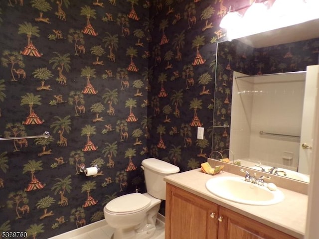 full bath featuring toilet, wallpapered walls, and vanity