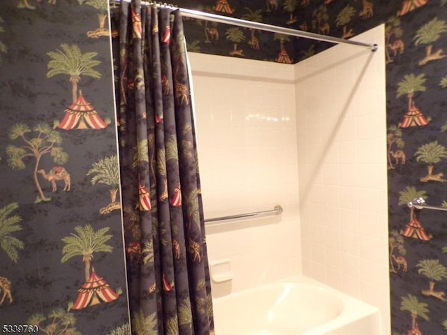 full bathroom featuring shower / bath combo and wallpapered walls