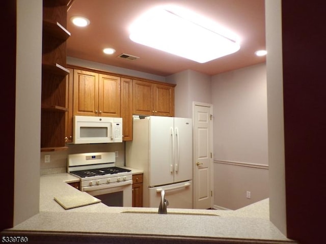 kitchen with brown cabinets, white appliances, open shelves, and light countertops