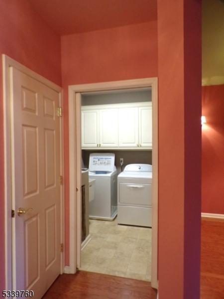 washroom featuring cabinet space, baseboards, and separate washer and dryer