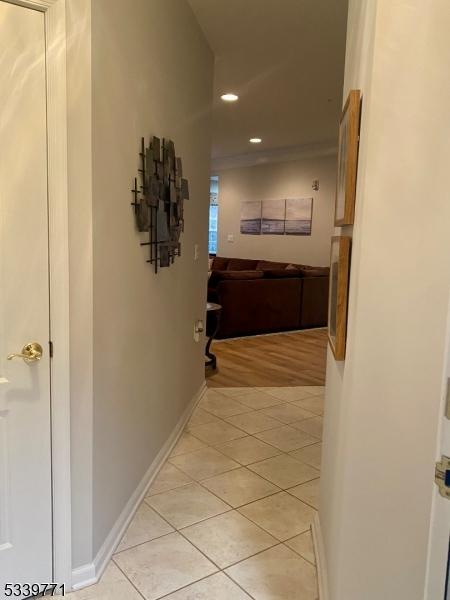 hall with baseboards, light tile patterned flooring, and recessed lighting