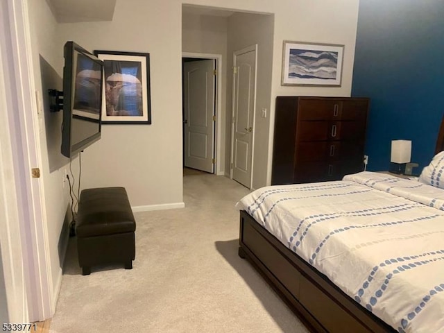 bedroom featuring baseboards and light colored carpet