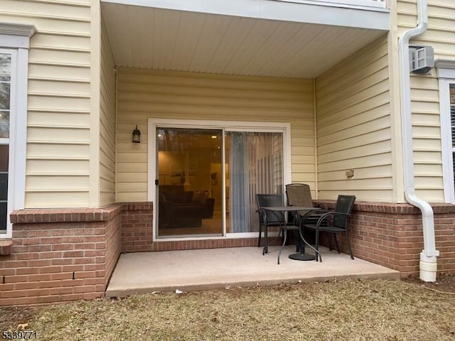 doorway to property featuring a patio area and brick siding