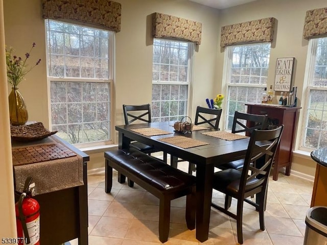 dining area with light tile patterned floors and baseboards