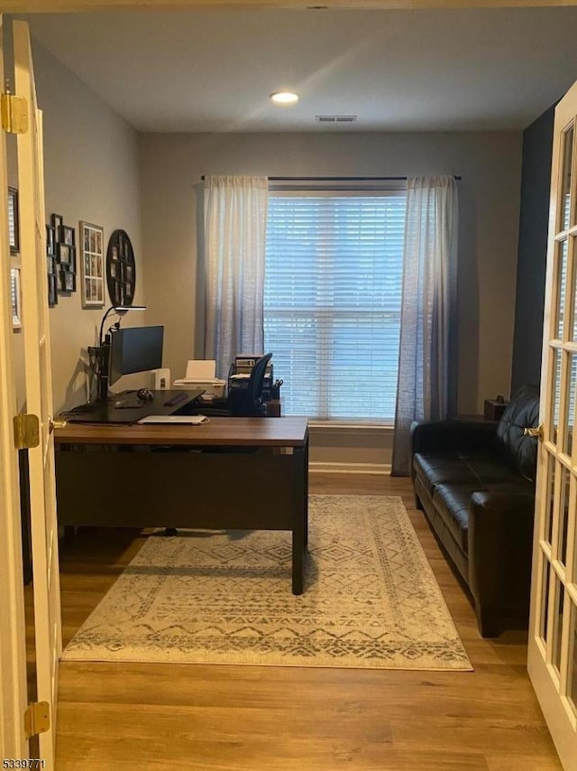 office area featuring french doors, wood finished floors, and visible vents