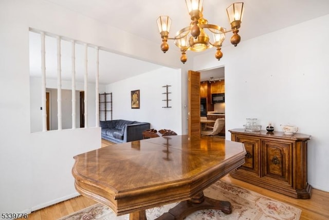 office area with light wood finished floors and an inviting chandelier