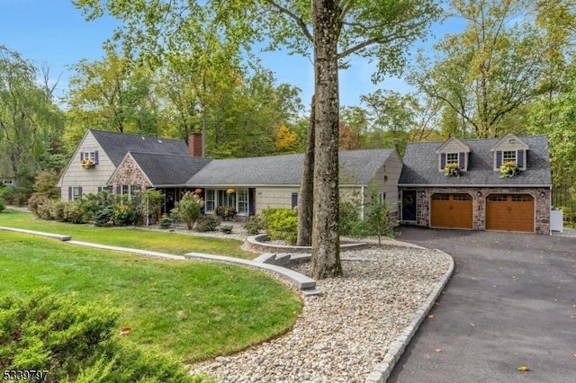 cape cod house with a garage, aphalt driveway, and a front yard