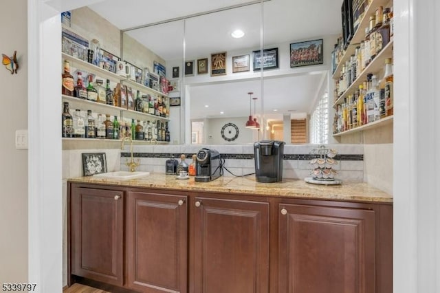 bar with decorative backsplash, a sink, and wet bar