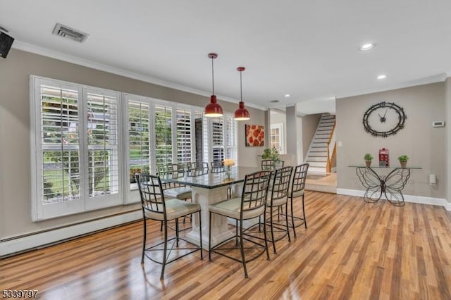 dining space with ornamental molding, visible vents, light wood-style floors, and stairs