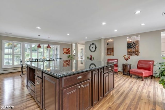 kitchen with a center island, pendant lighting, light wood finished floors, a baseboard radiator, and dark stone countertops