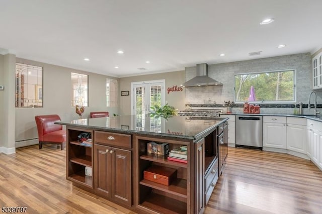 kitchen featuring wall chimney exhaust hood, a center island, white cabinetry, open shelves, and stainless steel dishwasher