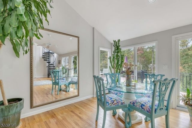 dining area with lofted ceiling, light wood-type flooring, stairs, and baseboards