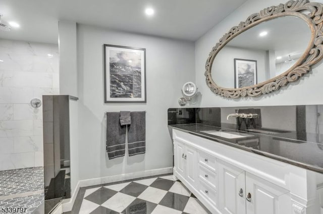 bathroom with recessed lighting, vanity, a walk in shower, baseboards, and tile patterned floors