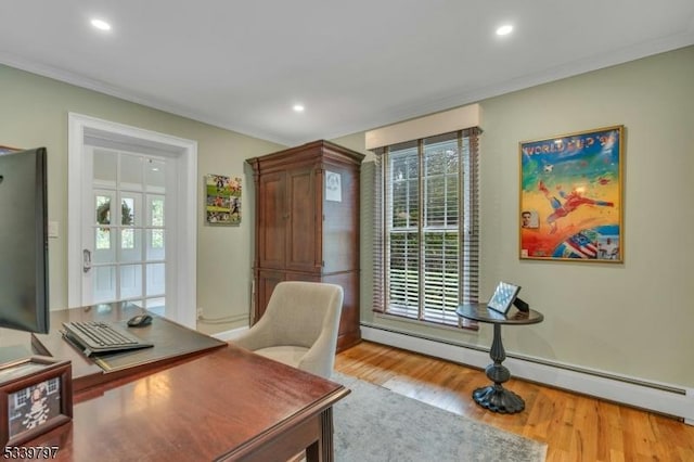 home office with light wood-style floors, a baseboard heating unit, and crown molding