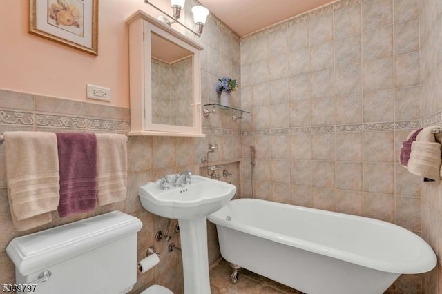 bathroom featuring a soaking tub, tile walls, and toilet