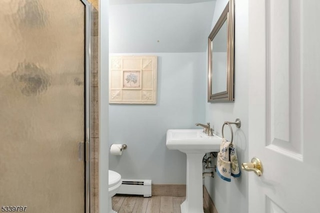 full bath featuring a baseboard radiator, a shower with shower door, toilet, wood finished floors, and baseboards