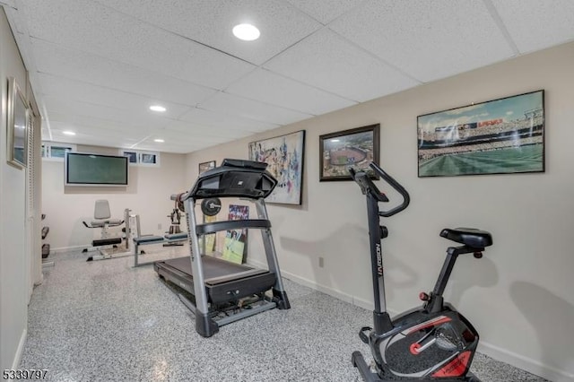 exercise room featuring recessed lighting, a drop ceiling, and baseboards