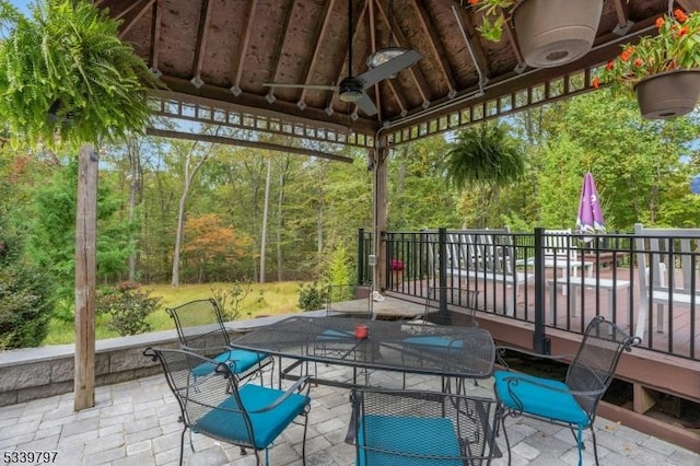 exterior space with a gazebo, a ceiling fan, and outdoor dining space