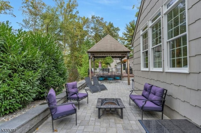 view of patio featuring a gazebo and an outdoor living space with a fire pit