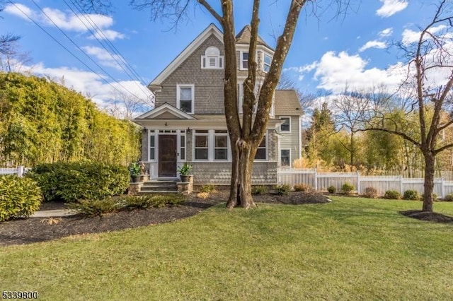 rear view of property with fence and a yard