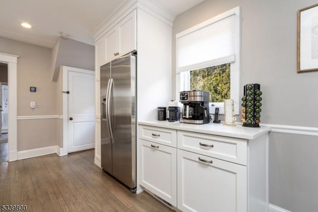 kitchen with stainless steel refrigerator with ice dispenser, recessed lighting, light countertops, white cabinets, and wood finished floors