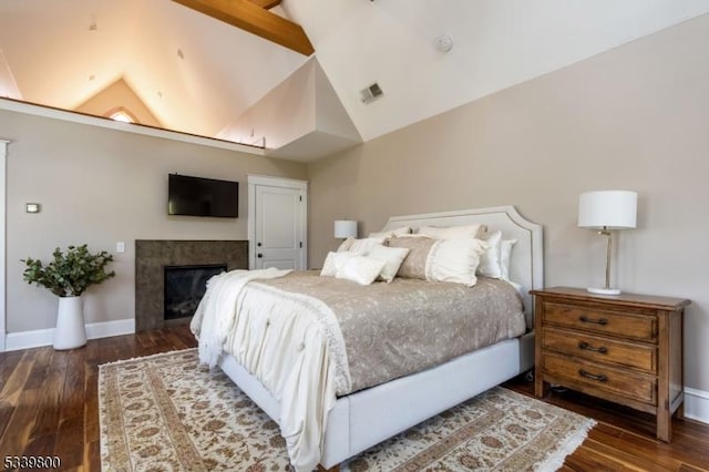 bedroom featuring vaulted ceiling, baseboards, and wood finished floors