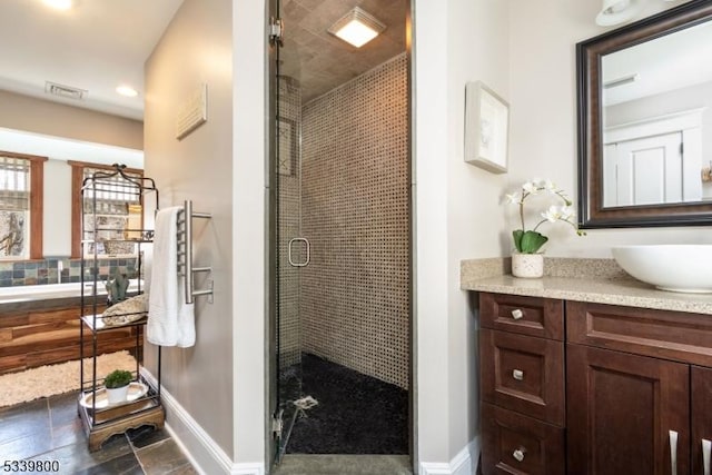 full bath with a stall shower, baseboards, visible vents, and vanity