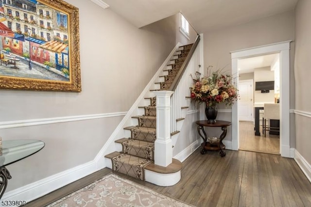 stairway featuring baseboards and hardwood / wood-style flooring