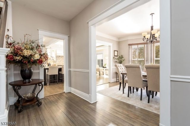 dining space with hardwood / wood-style flooring, baseboards, and a chandelier