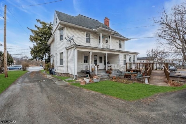 view of front of property featuring a chimney and a porch