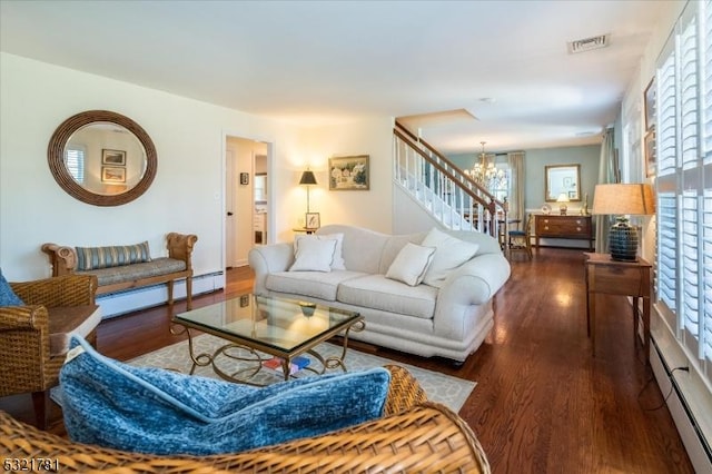 living area featuring a baseboard heating unit, a chandelier, visible vents, and dark wood finished floors