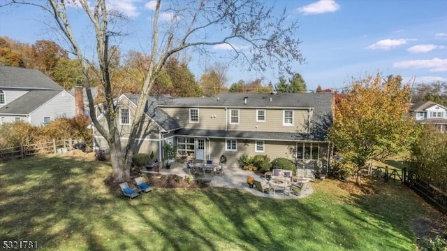 back of house with fence, a lawn, and a patio