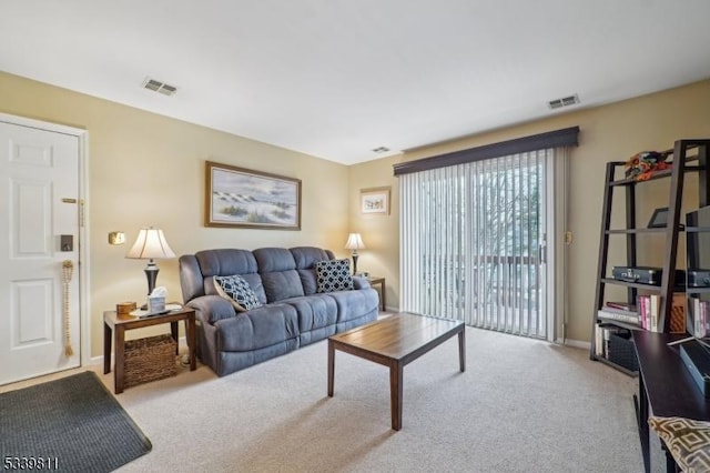 carpeted living area featuring visible vents and baseboards