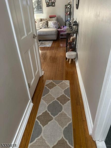 hall with baseboards and wood finished floors