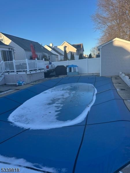 view of swimming pool with a deck and fence