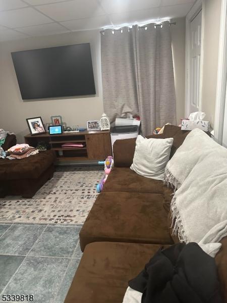 living room featuring a paneled ceiling