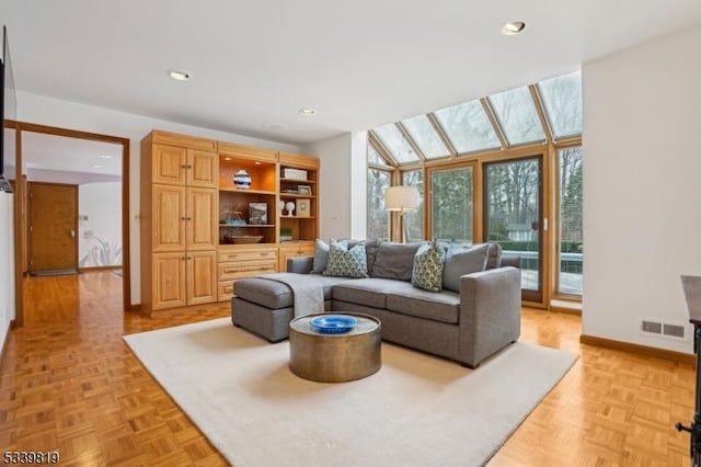 living room featuring baseboards, visible vents, and recessed lighting