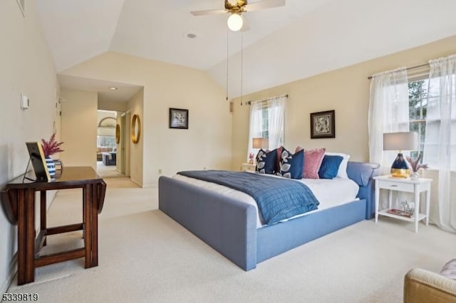 bedroom featuring ceiling fan, vaulted ceiling, and light colored carpet