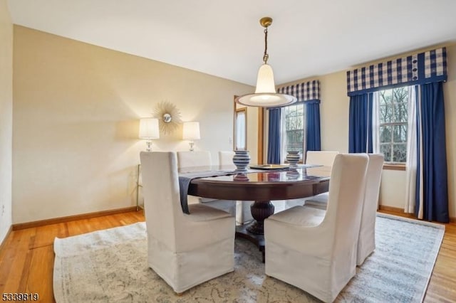 dining room featuring light wood-style flooring and baseboards