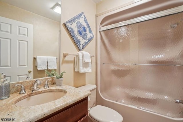 bathroom with enclosed tub / shower combo, toilet, and vanity