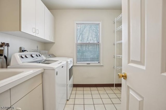 laundry room with cabinet space, independent washer and dryer, baseboards, and light tile patterned flooring