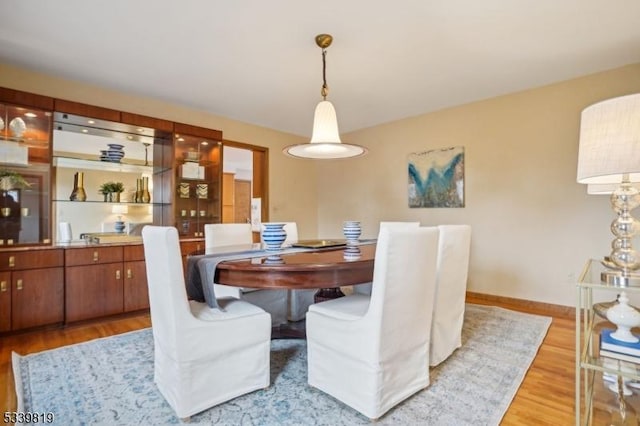 dining room with light wood-style flooring and baseboards