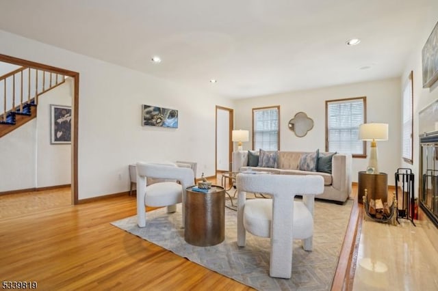 living room with stairs, light wood-type flooring, baseboards, and recessed lighting